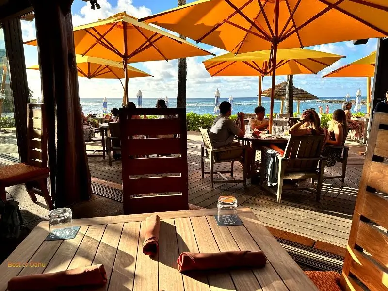 Beach House By Roy Yamaguchi Beach House By Roy Yamaguchi outdoor seating by the ocean.