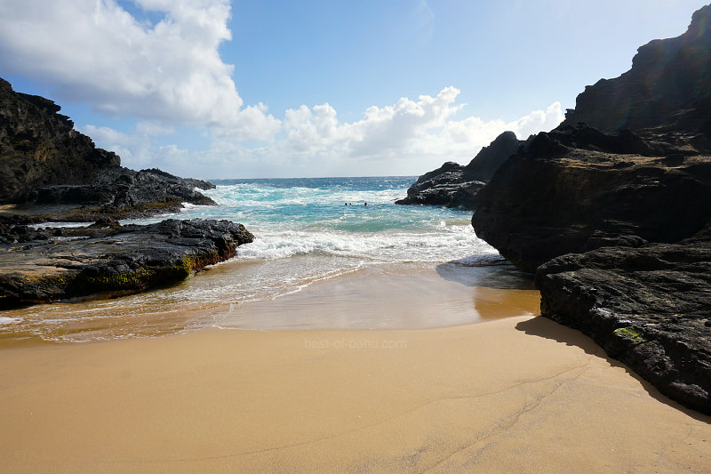 Eternity Beach in Oahu is a stunning coastal scene with golden sand, clear blue waters, and rugged cliffs on the southeastern shore, offering a picturesque and serene setting.