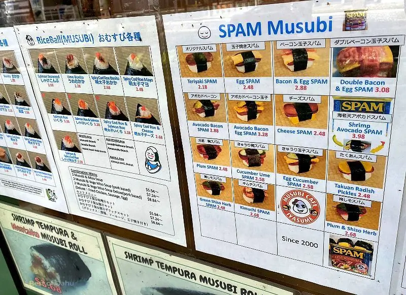 Musubi Cafe in Waikiki Musubi Cafe in Waikiki. A menu sign with pictures of different types of musubis.